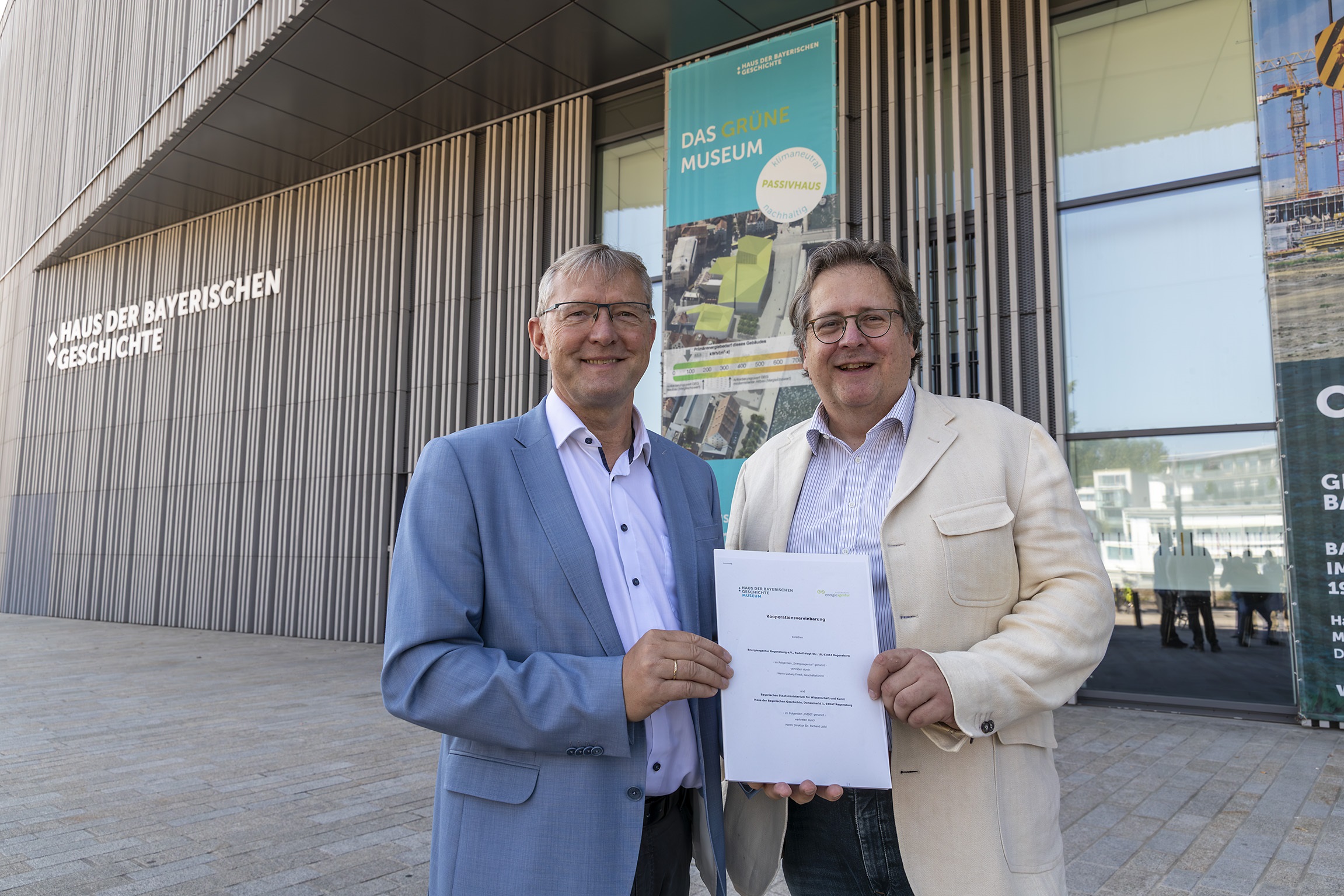 Ludwig Friedl, Geschäftsführer der Energieagentur Regensburg e.V. und Dr. Richard Loibl, Direktor des Hauses der Bayerischen Geschichte, präsentieren vor dem Gebäude am Donaumarkt die Kooperationsvereinbarung.  © HdBG | Foto: www.altrofoto.de